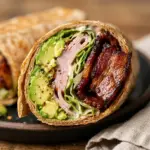 High-protein turkey avocado bacon wrap with fresh ingredients and vibrant colors.