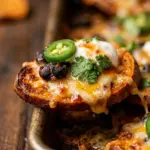 Sheet pan loaded sweet potato nachos topped with cheese and jalapeños