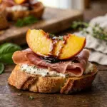 Delicious Peach Prosciutto Crostini with balsamic glaze on a rustic board