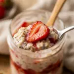 Bowl of Strawberry and Cream Overnight Oats topped with fresh strawberries.