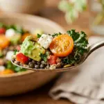 A colorful bowl of Kitchen Sink Salad with various veggies and toppings.