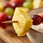 Colorful fruit kabobs with marshmallow dip on skewers