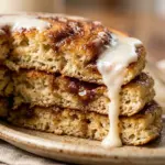 Delicious homemade cinnamon roll pancakes topped with icing and cinnamon