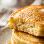 Delicious stack of fluffy pancakes topped with syrup and berries