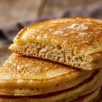 Deliciously fluffy sourdough pancakes served with syrup and fresh fruit.